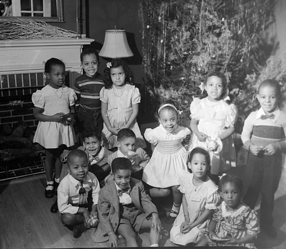 Group portrait: Young boys and girls posing infront of fireplace and Christmas tree, December 1949, Paul Henderson, MdHS, HEN.02.03-034.