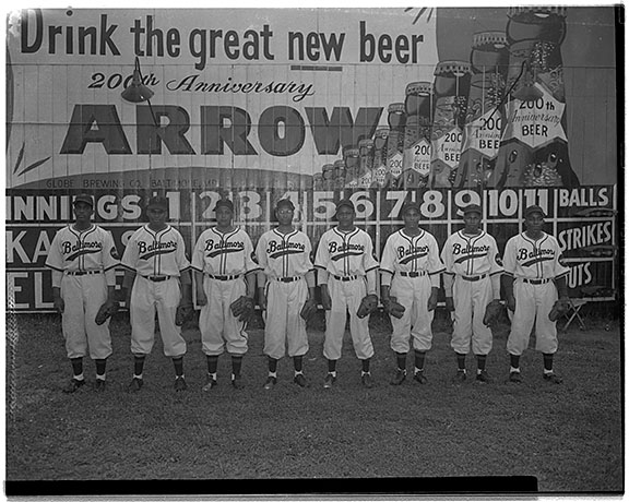 The Baltimore Elite Giants  posed in front of billboard advertisement for the 200th anniversary for Arrow Beer.  Group portrait, May 1949. Photograph by Paul S. Henderson. Paul Henderson Photograph Collection. HEN.00.A1-056, MdHS. 