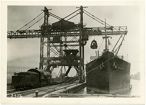 Loading ore onto an awaiting freighter.Port Covington Western Maryland Railway Ore Pier, 1931, Tourist Development Bureau, Subject Vertical File, MdHS.