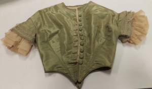 The jacket of a gown worn by Mrs. Enoch Pratt. The jacket has faded due to light damage. 