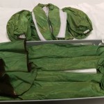 This green skirt and jacket have been padded and are about to be closed up in their new box.