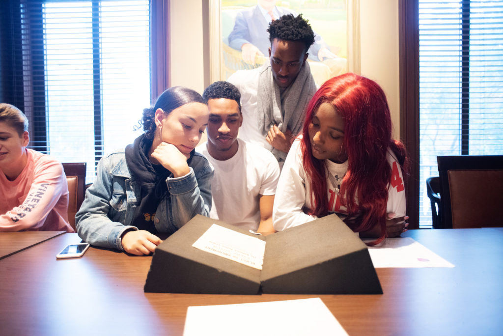 High schoolers look at a historic document while doing research at the Maryland Center for History and Culture.