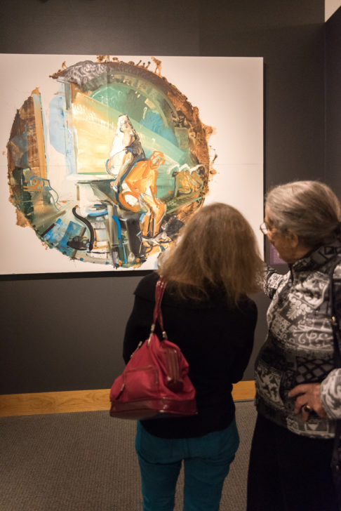 People viewing a painting in the Structure and Perspective exhibition.