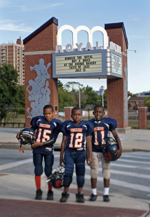 Youth in Baltimore stand beside a sign proposing rebuilding the Royal Theater.