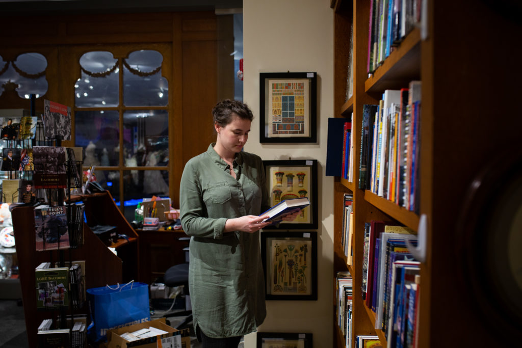 A woman looking at a book in the MCHC museum store.