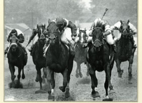 Photo of horses running on a racetrack.