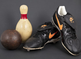 Duck pin bowling ball and pin and Orioles baseball cleats.