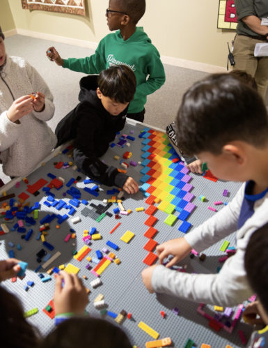 Children playing at a lego table in a museum gallery.