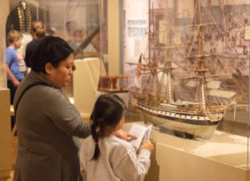 Two visitors looking at a model ship.